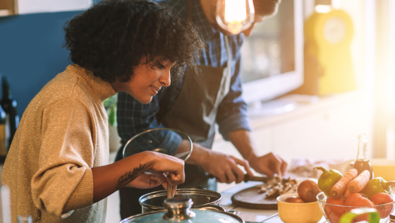 twee mensen staan in de keuken te koolhydraatarm eten te koken