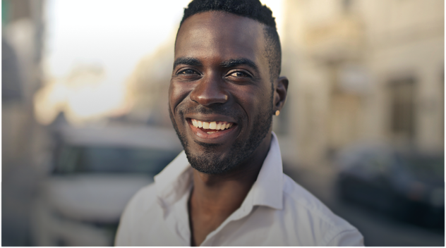 man lachend op straat met een wit bloesje aan man lachend op straat met een wit bloesje aan