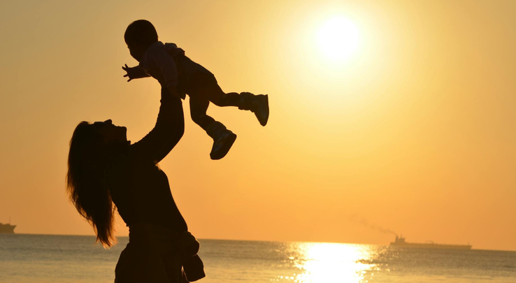 vrouw met kindje tijdens ondergaande zon vrouw met kindje tijdens ondergaande zon