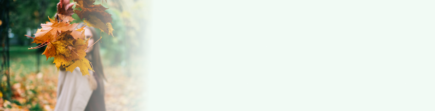 vrouw gooit herfskleurige bladeren in de lucht