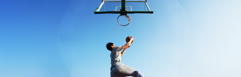 man die buiten basketball speelt met een blauwe lucht
