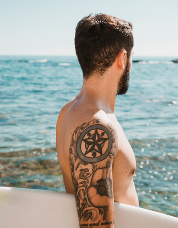 Man met tattoo bij de zee