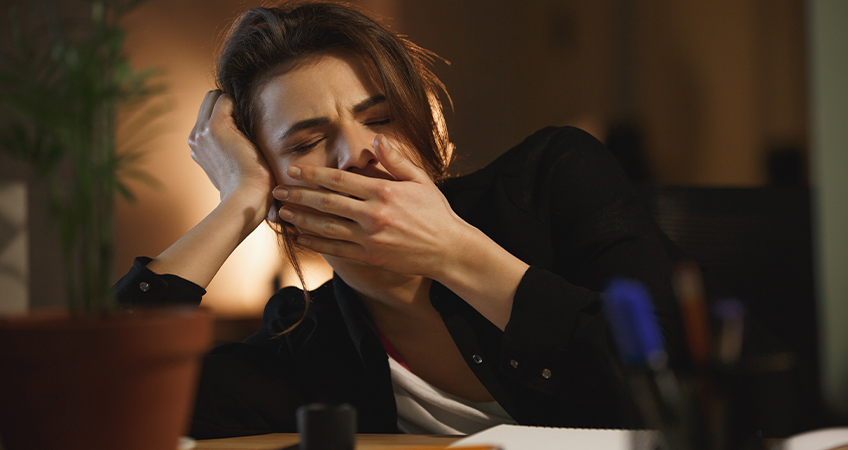 Gapende vrouw aan tafel Gapende vrouw aan tafel