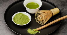 Een set matcha benodigdheden bestaande uit matchapoeder, een matchascoop en een bamboe klopper, klaar voor het bereiden van een kop matcha