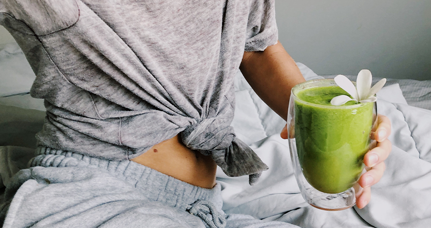 matcha smoothie wordt vastgehouden door vrouw in bed