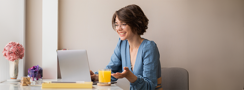 Lachende, energieke vrouw aan het werk achter haar bureau Lachende, energieke vrouw aan het werk achter haar bureau