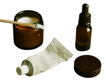 Een open potje een lege tube tandpasta en een half leeg flesje met een pipet Een open potje een lege tube tandpasta en een half leeg flesje met een pipet