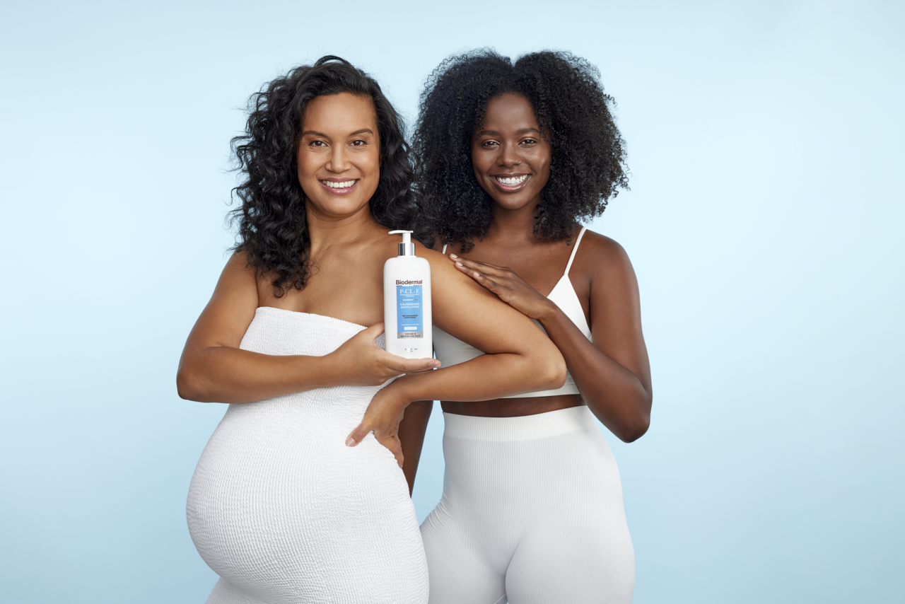Two women dressed in white standing next to each other and holding Biodermal P-CL-E Crème Two women dressed in white standing next to each other and holding Biodermal P-CL-E Crème