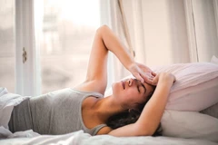 vrouw in bed met hoofdpijn vrouw in bed met hoofdpijn
