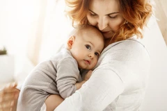 vrouw met baby tegen haar aan